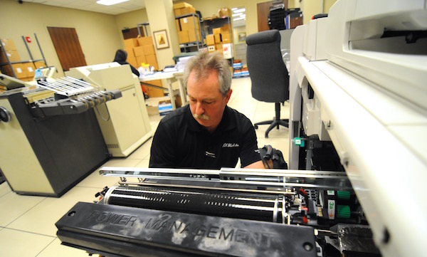 R.K. Black service technician Dwain Foss works on an Oce VaroPrint 110 production printer.